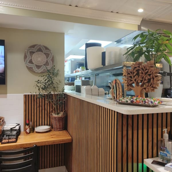 The Olive Bistro's counter with a wooden tree sculpture, candy, and a view into the kitchen.